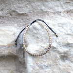 Charger l'image dans le visualiseur de galerie, Bracelet de couleur gris ombré et or en perle de verre Miyuki posé sur mur de pierre. Fabriqué à Saumur France